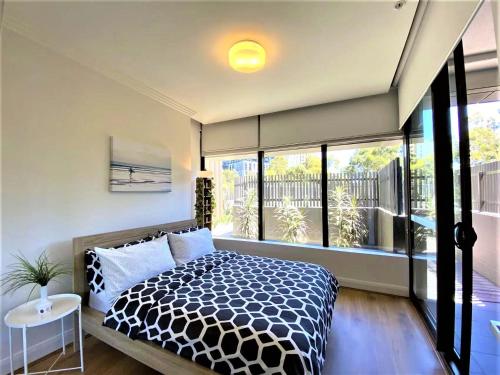 悉尼Greenview in Sydney Olympic Park的一间卧室设有一张床和一个大窗户