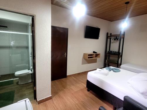 巴拉那瓜Hotel Serra do Mar的一间卧室配有一张床,浴室设有卫生间