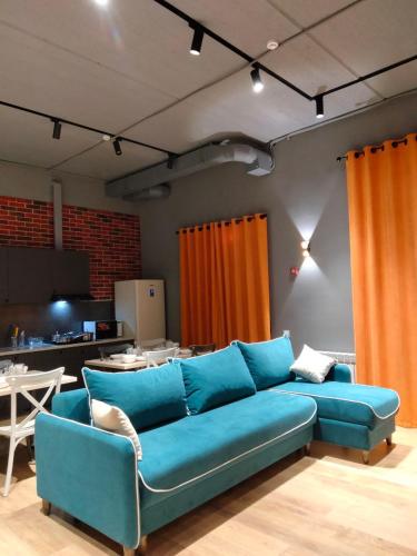 阿斯塔纳Hostel Bro Astana的客厅配有一张蓝色的沙发,配有一张桌子