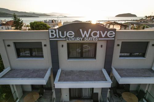 伊拉克里萨Blue Wave Luxury Suites的大楼一侧的蓝波豪华套房标志