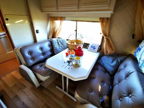 波尔蒂芒Rent a BlueClassics 's Campervan le Voyageur In Algarve au Portugal的客厅配有桌子和沙发