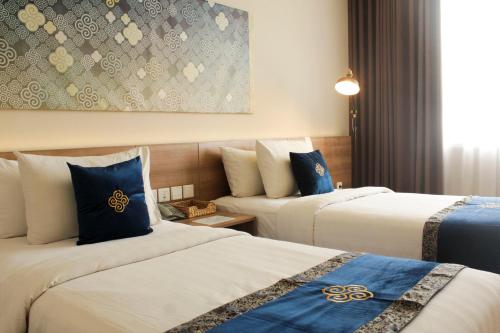 芝卡朗Antero Hotel Jababeka的酒店客房 - 带两张带蓝色枕头的床