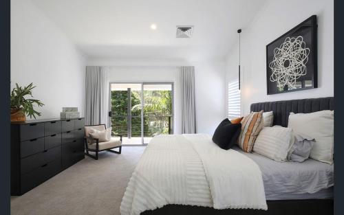 巴托湾Central Coast - Luxurious Beach House 400m to Beach的一间卧室设有一张大床和一个窗户。