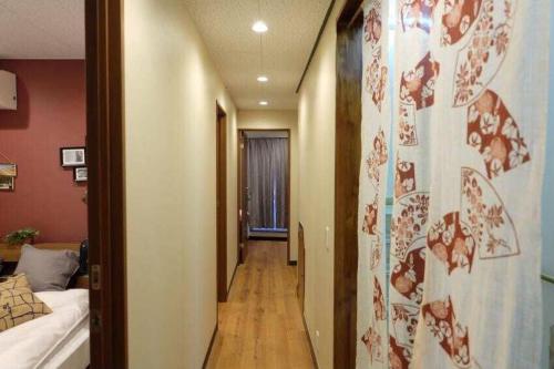 东京AN HOTEL的走廊通往带床的房间和走廊的四柱床