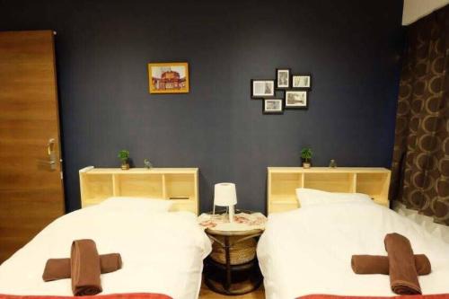 东京AN HOTEL的一间卧室配有两张带棕色十字架的床
