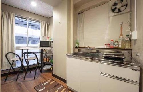 东京AN HOTEL的厨房配有柜台和桌椅