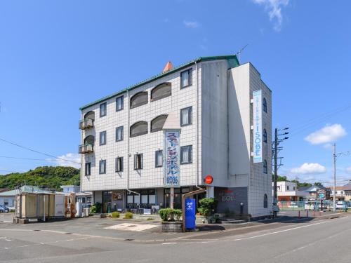 志摩市Tabist Station Hotel Isobe Ise-Shima的街道拐角处的白色大建筑