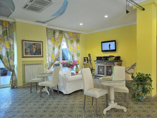 马奥莱米拉马雷酒店的客厅设有黄色的墙壁、桌子和壁炉