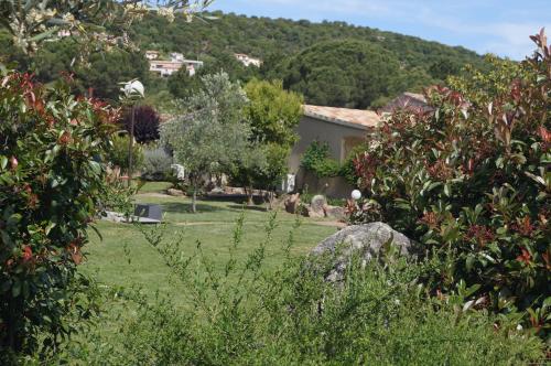 维琪奥港Les Jardins De Santa Giulia - Charmante chambre d'hôte的一座花园,后面有一座房子