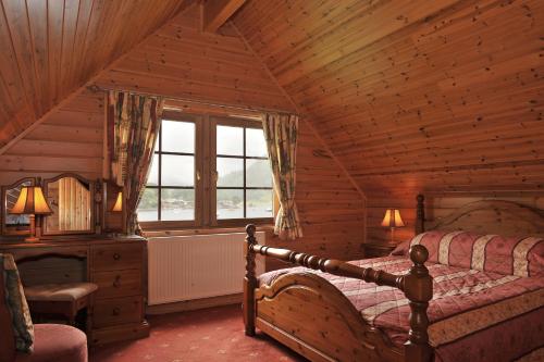 Ardlui阿德卢伊洛赫赛德山林小屋的小木屋内一间卧室,配有一张床