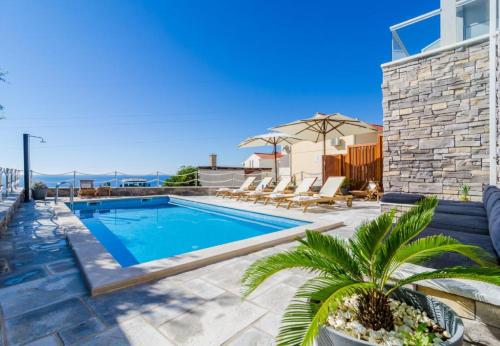 米利尼Apartments Villa Capitano的一个带躺椅的游泳池以及一间房屋
