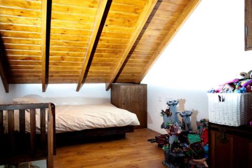 La ÑoraEl vergel encantado的一间卧室设有一张木天花板床。
