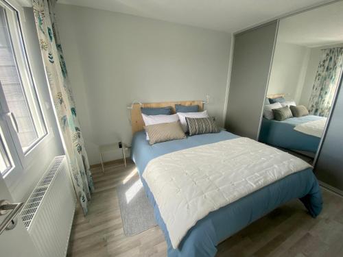滨海贝尔克Appartement de standing VUE MER的一间小卧室,配有一张床和镜子
