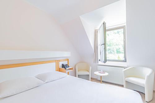 叙尔河畔埃施乐博斯蒂隆酒店的一间卧室配有一张床和两把椅子