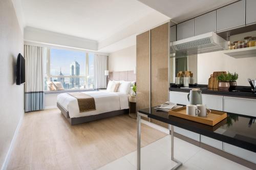 香港麦当劳道贰号酒店式服务住宅公寓的一间卧室配有一张床和一张书桌,厨房