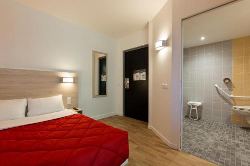圣埃尔布兰Premiere Classe Nantes Ouest - St Herblain的酒店客房设有红色的床和浴室。