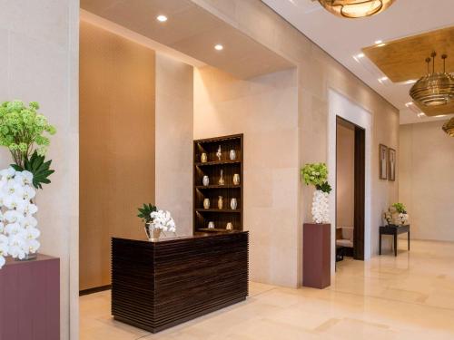 多哈Alwadi Hotel Doha - MGallery的花瓶花的酒店大堂