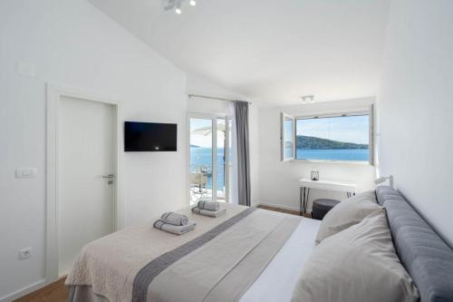 拉扎尼Villa Marijo的白色卧室设有一张大床和电视。