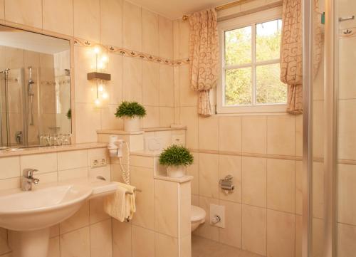 基兴佐姆维根斯汀酒店的一间带水槽和卫生间的浴室以及窗户。