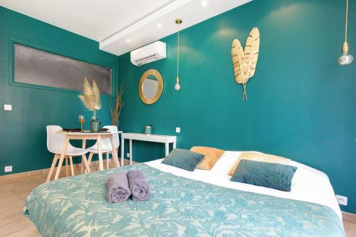 戛纳Love Suite and SPA - CANNES的一间卧室配有一张蓝色墙壁的床和一张桌子
