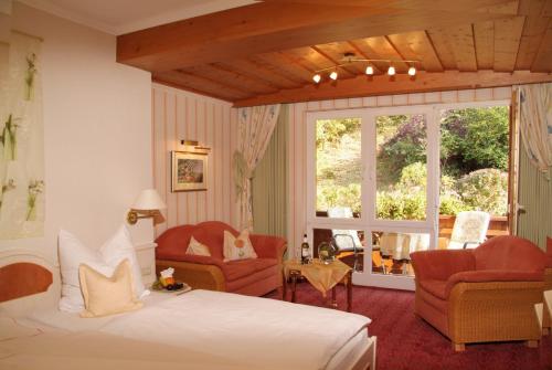 基兴佐姆维根斯汀酒店的一间卧室配有一张床、两把椅子和一个窗户