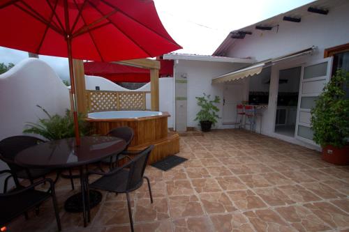 阿约拉港祖日塞待旅馆的一个带桌子和红色遮阳伞的庭院