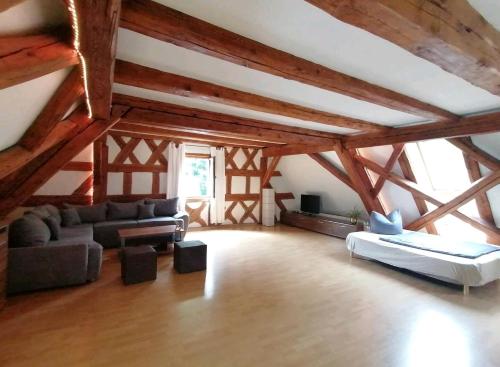 科琴斯顿巴赫Loft auf altem Gutshof的大型客厅设有木制天花板和木梁。