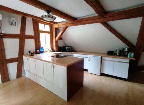 科琴斯顿巴赫Loft auf altem Gutshof的厨房配有白色橱柜和木制天花板