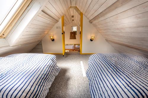 栋堡Vakantiehuis Domburg Cabanas DO37的阁楼上的卧室配有两张床