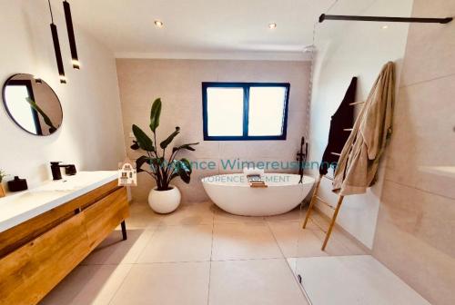 WimilleMagnifique villa avec jaccuzi的一间带大浴缸和水槽的浴室