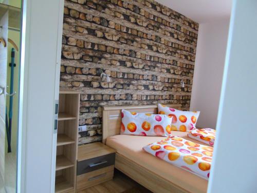 OberweidFerienwohnung Csilla 2的一间卧室设有砖墙和一张床