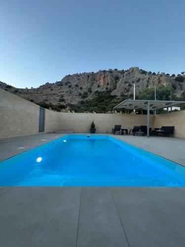 佩基罗德Tesoro Del Mare的一座蓝色的游泳池,后面是一座山