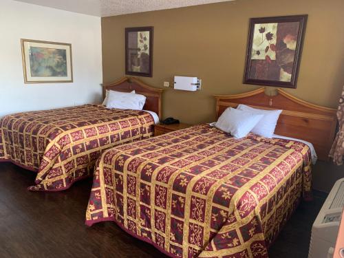 图珀洛Economy Inn的一间酒店客房,房间内设有两张床