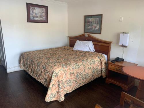 图珀洛Economy Inn的酒店客房配有一张床铺和一张桌子。