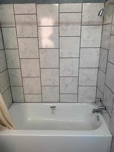 图珀洛Economy Inn的浴室设有白色浴缸。