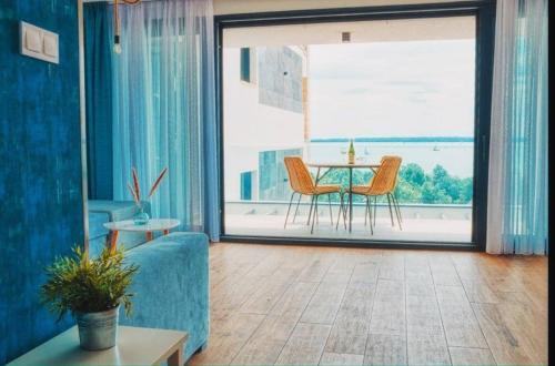 下厄尔什365Balaton Apartmanok的客厅配有蓝色的沙发和桌子