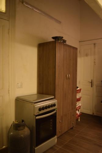 特拉布洛斯City Hostel Dormitory的一间带炉灶和木柜的厨房