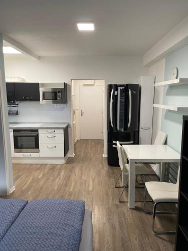 VšeminaVšemina apartmán 31的厨房配有桌子和黑冰箱。
