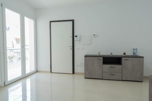 波扎洛Raganzino Apartment Pozzallo - new building的白色的房间,设有厨房、水槽和门