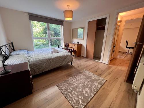 格拉斯哥Lovely 2-Bed Serviced apartment with free parking的一间卧室配有一张床,铺有木地板。