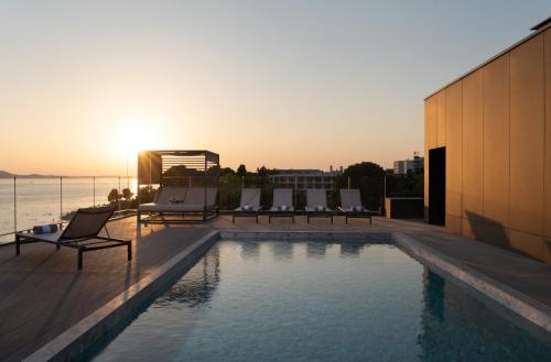 扎达尔La Vista Suites的一座享有日落美景的建筑屋顶上的游泳池