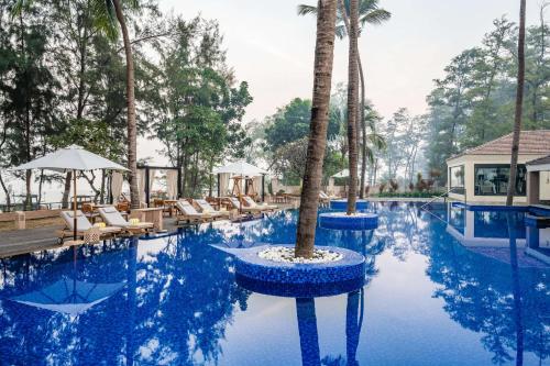 达曼Silver Waves Resort & Spa Daman, a member of Radisson Individuals的棕榈树中心度假村的游泳池