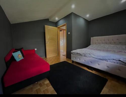 萨拉热窝Villa Dream的一间卧室配有一张床和一张红色的沙发
