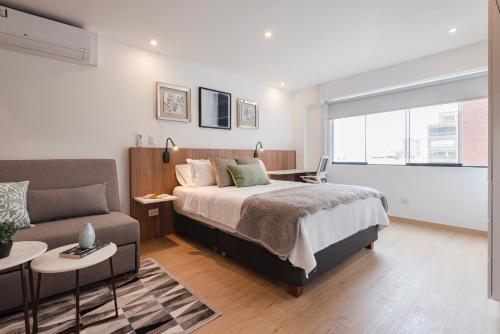 利马ALU Apartments - Miraflores f/Doubletree Hilton c/AC Wifi+60M的一间卧室配有一张床和一张沙发