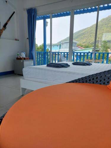 格兰岛Blue sky Koh larn Resort的一间卧室设有一张床和一个大窗户