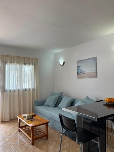 宏达海滩Apartamento Playa Honda的客厅配有蓝色的沙发和桌子