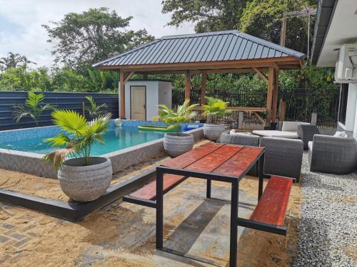 帕拉马里博Tropical appartement的后院设有游泳池、桌子和凉亭
