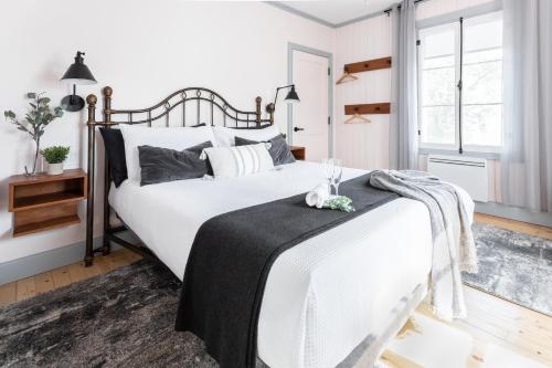 Saint-JeanLa maison de l'île的卧室配有一张带黑色毯子的大型白色床。