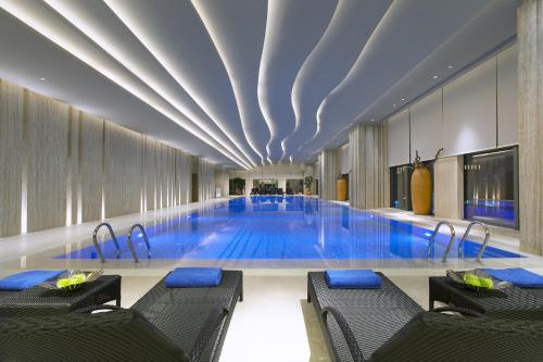 东莞东莞富力万达文华酒店的大楼内带椅子的大型游泳池
