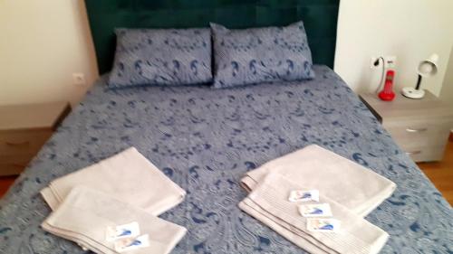 Glyka NeraImmaculate 2-Bed Apartment的一间卧室配有蓝色的床和毛巾